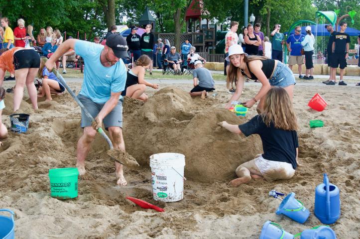Chris Woelfel, Ellie Wood, 13, and Gia Woelfel, 11, worked on their sand sculpture masterpiece — a boat adorned with a Dragon’s head — during the Watercade sand sculpture contest at Lake Ripley, The Woelfel-Wood team captured first place in their division.