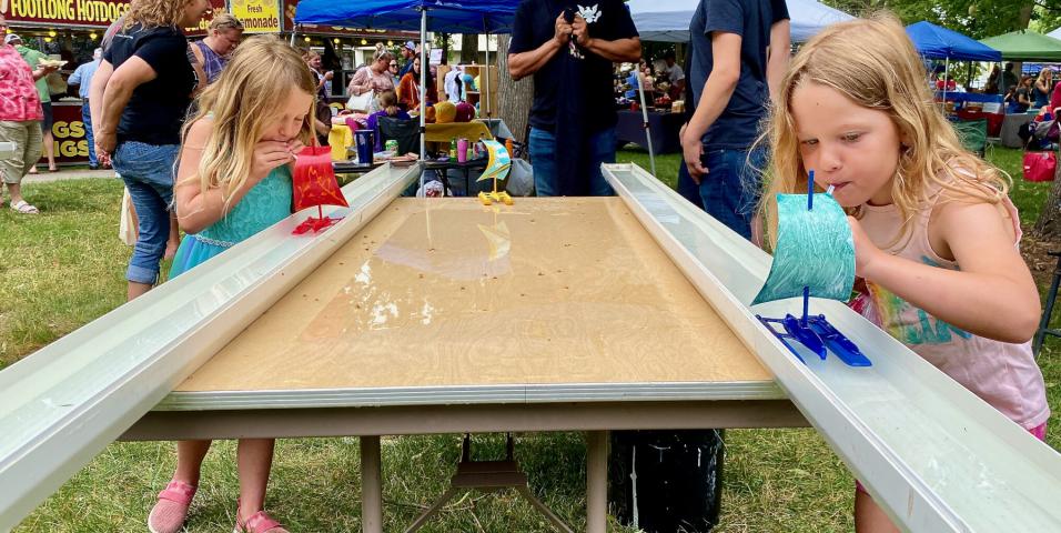 Alison Holes, 6, and Aliza Laidlaw, 5, used their own wind power to push boats down water-filled tracks. The game was part of the Litchfield Cub Scouts’ booth during Watercade’s Art in the Park Saturday morning in Central Park.