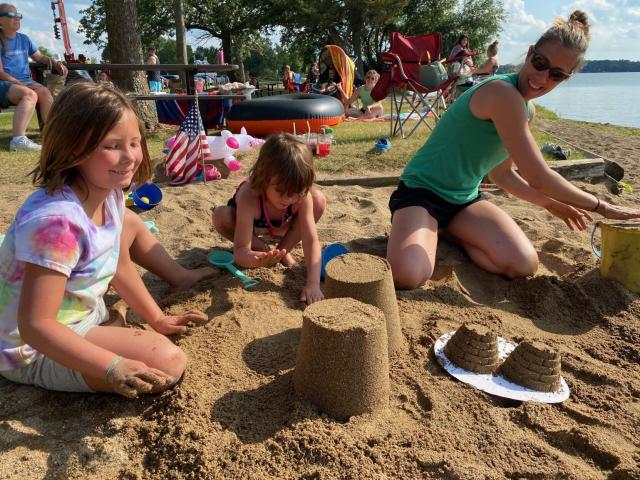 Brandy Fischer, right, builds a sand castle with her daughters, Bailey, 7, and Ayla, 5, during the sand sculpture contest Friday afternoon at Lake Ripley beach.