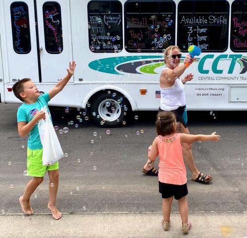 Central Community Transit’s parade entry has children chasing bubbles during the Grand Day Parade Saturday.