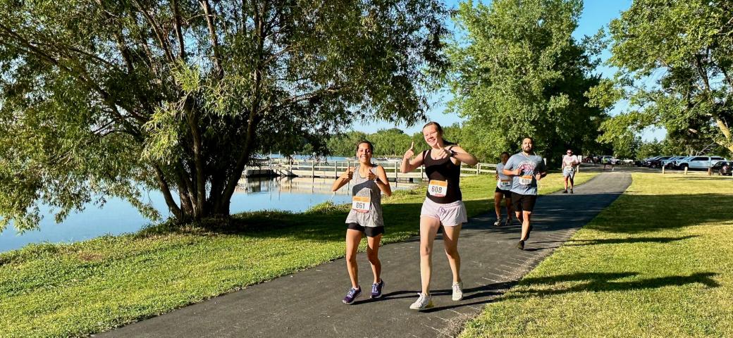 Tynisa Lara and Lia Caron give a thumbs-up sign as they reach the halfway point of Saturday's 4-mile run.