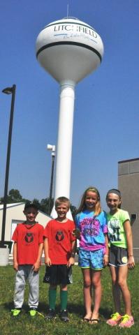 Four Litchfield students found the Watercade medallion July 10 under a pine tree near the water tower. Medallion hunters, from left, are 7-year-old Jack McCann, 10-year-old Logan King, 10-year-old Sydney McCann and 9-year-old Alexis Hansen.