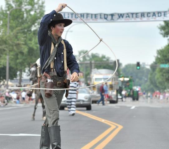A cowboy with a lasso from the “Shadows of the Old West” show walks in the Grand Day Parade.