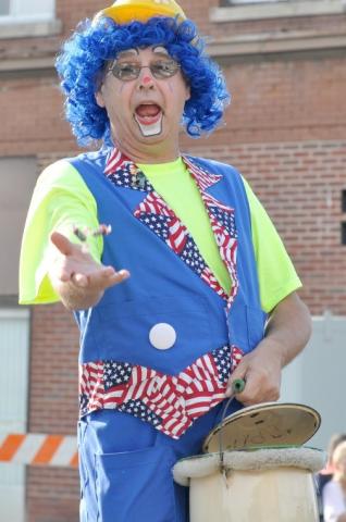 A clown hands out candy on the Watercade Grand Day Parade route Saturday.