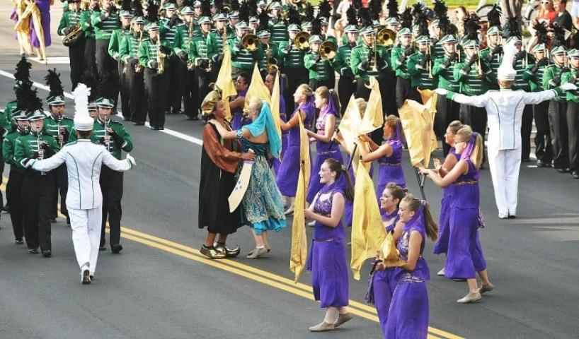 Sophomore Mitch Evans, portraying a Persian king, and sophomore Anika Ellingson, as Scheherazade, dance amidst the Litchfield High School marching band Saturday during the Watercade Grand Day Parade.