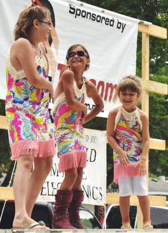 Megan Thoma, 10, Tasha Dullinger, 8, and Abby Thoma, 8, laugh as they perform “Dancing Queen” by ABBA. The girls formed a trio named “The Hippie Chicks” during the Watercade lip sync contest Saturday afternoon in Central Park. First place in the contest went to Alyssa, Braden and Ty Olson, along with Sydney, Grace and Stella Braaten, who performed “Oakridge Kids.” Second place went to Chelsea and Cali Ficker, and third place went to Kennedy Erickson, Madison Erickson, and Emily Berg.