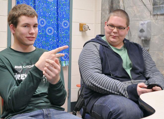 Litchfield High School students Carter Janorschke, a junior, and Bailey Snabb, a sophomore, chat with teacher Mary Carlson and an ASL interpreter during school last week. The two boys attended Camp Confidence with other deaf and hard of hearing students in February.