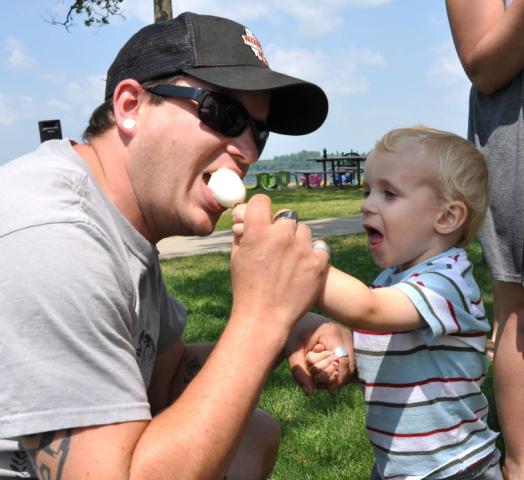 Maxxon Lembcke, 2, shares his egg on a stick with his dad, Nate Lembcke, Sunday at Memorial Park.
