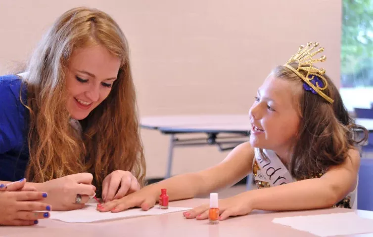 Miss Litchfield candidate Ali Richardson paints the nails of 8-year-old Kendra Ball during Watercade's Prince and Princess for a Day event Monday at Litchfield High School. Ball said her favorite part of the event is getting her nails painted by royalty candidates.