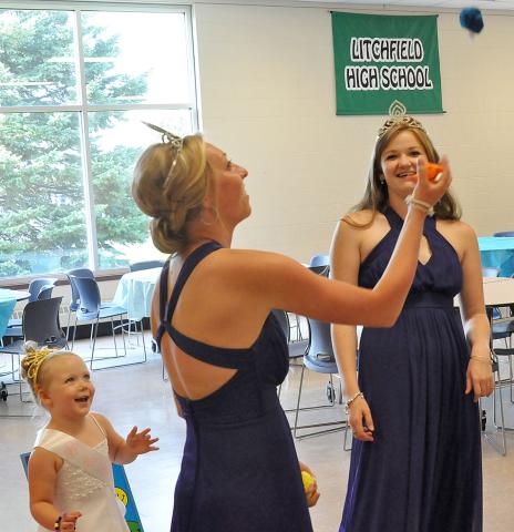 Litchfield Watercade princess Emily Schreiber shows off her juggling skills as princess Erika Hart looks on with amusement during the Prince and Princess for a Day event Monday.