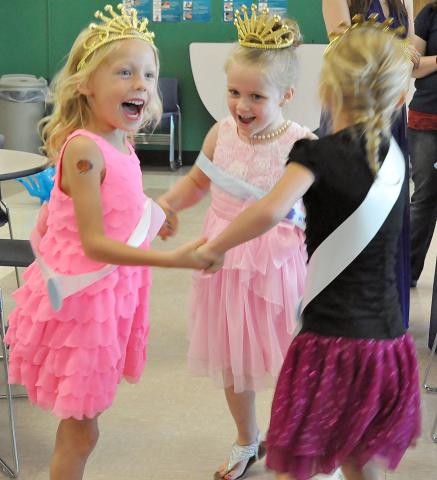Little princesses Elsie Daavettila, 4, Mallory Terning, 5, and Nina Daavettila, 4, pictured from left, twirl while singing “Ring Around the Rosy” at the Prince and Princess for a Day event.
