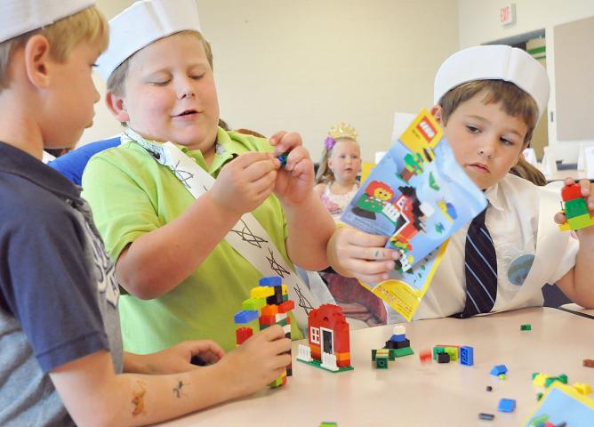 Ty Penk, Quintin Berube and Gavin Terning, pictured from left, play with Legos during the Prince and Princess for a Day event.