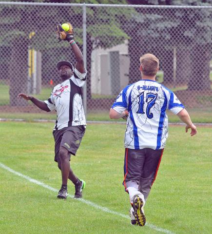 Left fielder David Knutson, left, of St. Cloud, pulls in a fly ball in short left field during his team Royal Pains’ 22-7 win over Hilltop Roadshop in Saturday’s men’s slow pitch softball tournament.