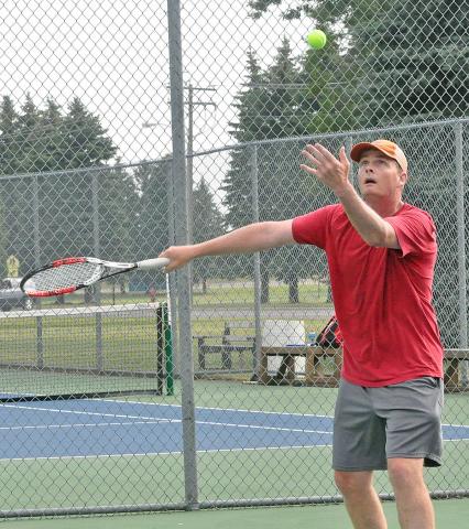 Karl Puckett, of Great Falls, Mont., watches his toss before serving in the Watercade Men’s A Doubles tennis tournament Saturday. Puckett and his brother Tim, of Fishers, Ind., took second in the tournament, losing 5-7, 4-6 to the Litchfield father-son duo of Donovan and Josh Prahl in the tournament final.