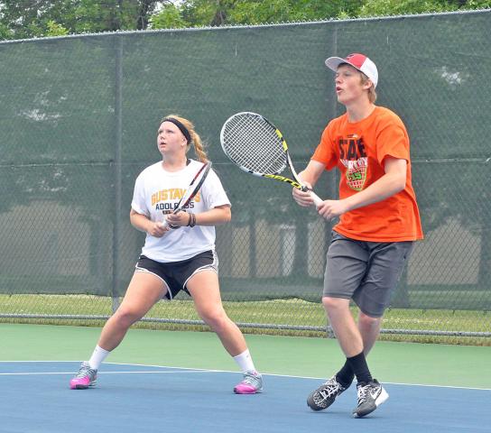 Kennedy Sommerfeld, left, and Josh Prahl, right, await a return shot in Saturday’s Watercade mixed doubles tennis tournament. Sommerfeld and Prahl lost their two matches in the tournament, but Prahl earned some redemption later in the day when he partnered with his father Donovan Prahl to win the Watercade Men’s A Doubles tournament.