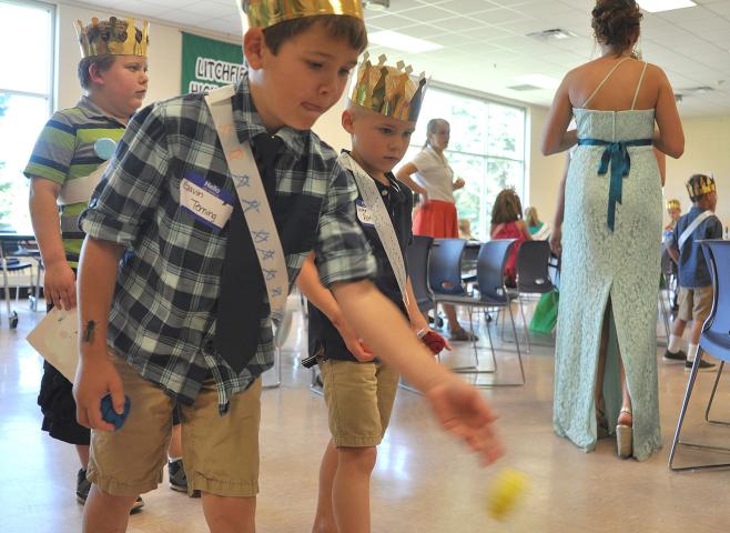 Gavin Terning tosses as bean bag while his friends Quintin Berube and Carter Rothstein watch.