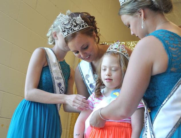 Watercade Princess Kaitlynn Beighley, Miss Litchfield Karly Nelson and Watercade Princess Autumn Raiber adjust Maggie Gaulrapp's sash and crown to get ready for a professional photo.