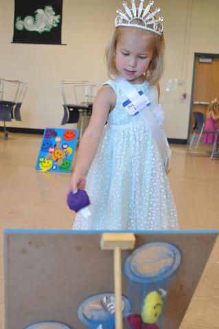 Ava Rothstein eyes her target before tossing a bean bag into the hole.