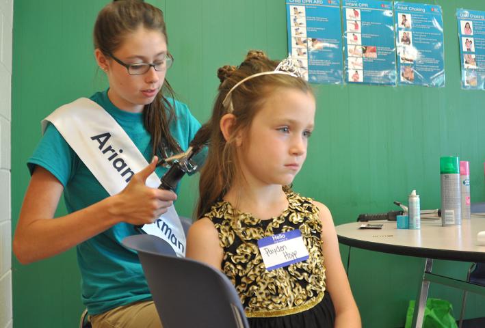 Watercade candidate Ariana Jackmen curls Payden Hopp's hair at the Prince and Princess for a Day event at the Litchfield High School.
