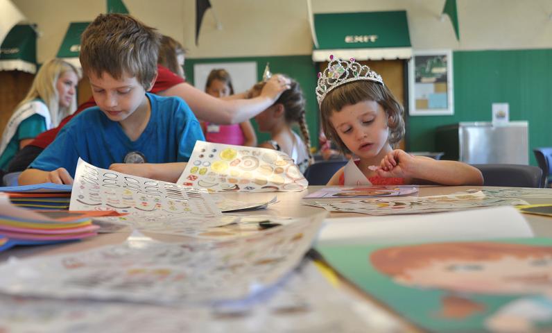 Shawn Bollin, 8, and his sister Hailey Bollin, 4, decorate pictures with sticker crowns and sashes.