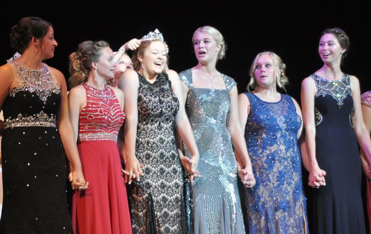 Princess Michelle Oster grins as she feels the crown being placed on top of her head.