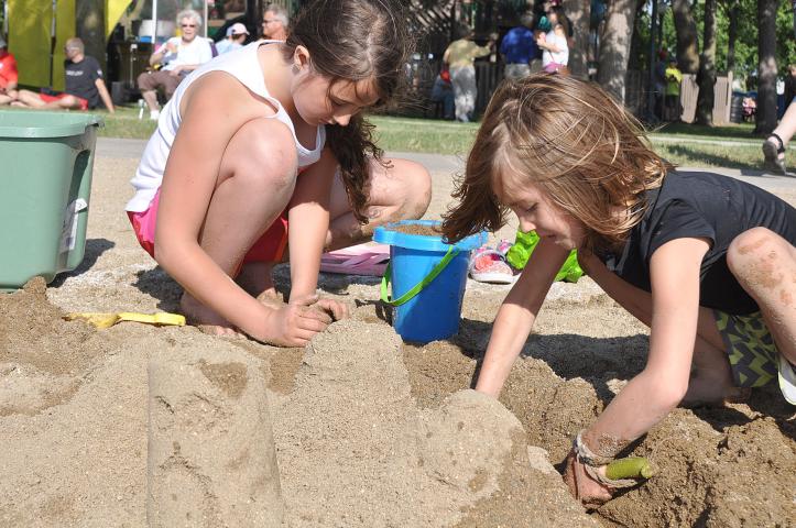 Ingrid Hansen, 9, and Elly Woelfel, 7, dig a trench around their sand castle which they filled with water to create a moat in a sand sculpture contest.