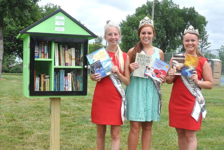 Watercade Princess Kaitlynn Beighley, Miss Litchfield Karly Nelson and Princess Autumn Raiber stock the Little Green Library at South Park with new children and adult books.
