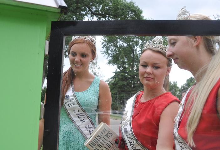 Miss Litchfield Karly Nelson and Princesses Autumn Raiber and Kaitlynn Beighley restock the Little Free Library at South Park Tuesday.