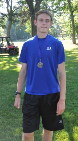 Adam Anderson, 17, of Dassel poses with his first place medal from the Watercade Lake Ripley Run. Anderson finished the 4-mile race with a time of 24:06 to win by 39 seconds