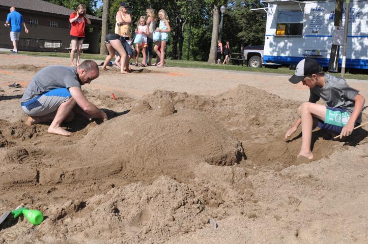 Chris, left, and Mason Woelfel of Litchfield made a large sand sculpture along the shores of Lake Ripley Friday evening. Team Woelfel took first place in the competition.