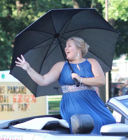 Newly crowned Miss Litchfield Brianna Larson made her way down main street during the Grand Day Parade, avoiding harsh UV rays beneath her umbrella.