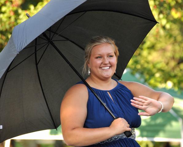 The day before she was crowned Miss Litchfield, Brianna Larson waved to spectators under her UV-protecting umbrella during the Watercade Grand Parade.