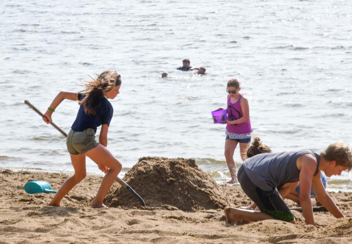 Participants of the sand sculpture contest work on their sculpture on the shores of Lake Ripley.