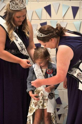 Miss Litchfield Brianna Larson and Princess Laura Shoutz help Jacie Carlson adjust her sash before she has her picture taken.