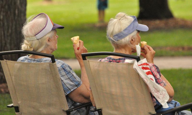 Sisters Shirley and Joyce Dahl relaxed in lawn chairs while eating ice cream and watching the Watercade Idol singing competition in Central Park.