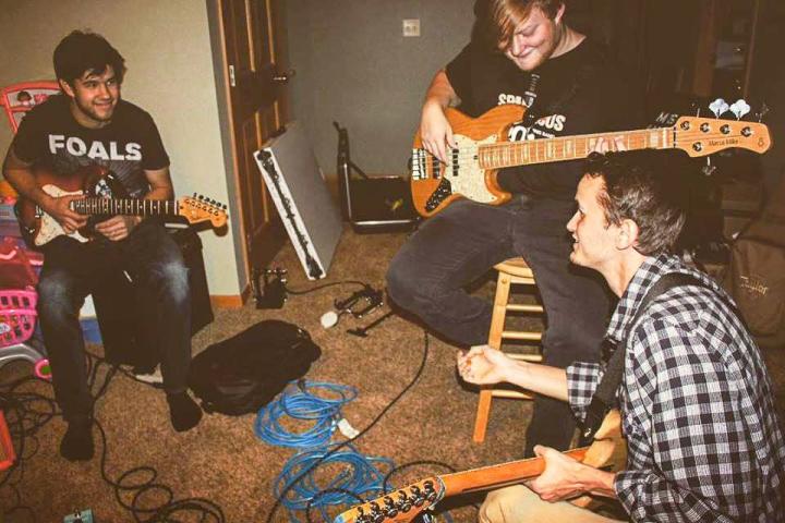 The band practices and writes songs during a jam session.