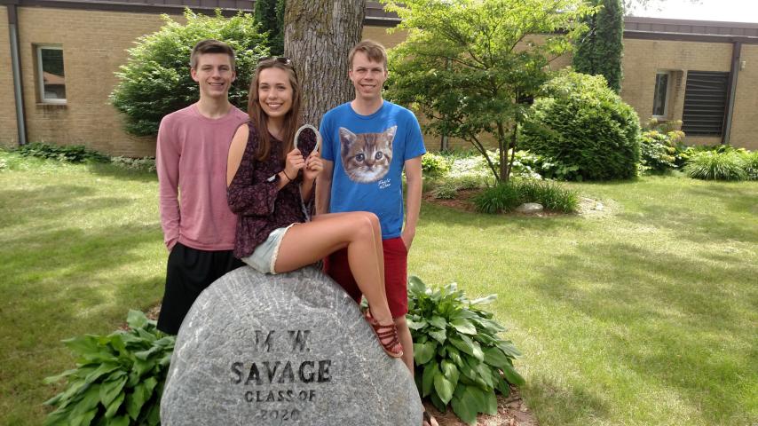 Savage residents Jacob, 18, Sarah, 20, and Daniel Halmrast, 22, pose at the spot where they found the horseshoe for the Dan Patch Days annual horseshoe hunt — M.W. Savage Elementary School. The Savage residents found the horseshoe with the help of their parents.