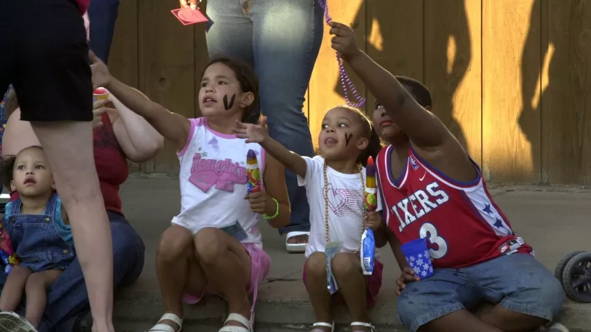 Sisters Jada Brown, 2, left, Net Brown, 8, Phajja Brown, 4, and friend Raekwon Johnson, 7, reach for beads during the 2003 Rice Street Parade. (Pioneer Press file)