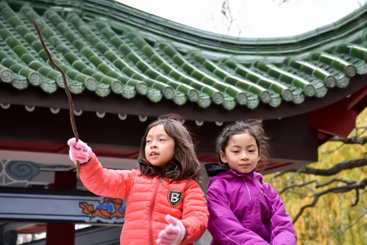 Anna Look, 6, left, of Ramsey, and her friend Kailyn Jiang, 7, of Brooklyn Park, play Saturday, Nov. 3, 2018 in front of the new Xiang Jiang Pavilion, a gift from St. Paul's sister city Changsha in China. The pavilion is the first phase of a 1.2 acre China garden in Phalen Park. The girls' mothers said they came to the event to teach their daughters about their Chinese heritage. (Deanna Weniger / Pioneer Press)