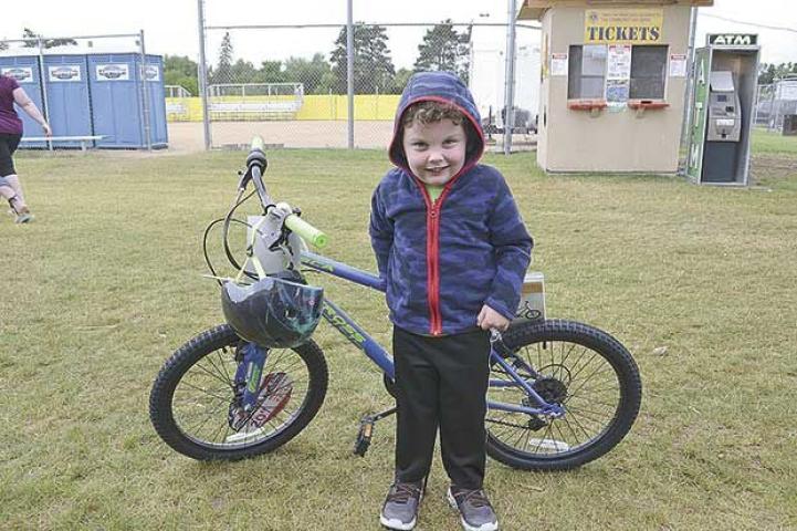 Mason Webb, 4, was thrilled to win the bicycle during the Sunday afternoon closing ceremony.