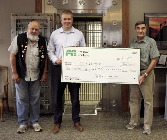 om Lauinger was the finder of this year’s Osseo Lions Roar Medallion. This year’s medallion was found Aug. 8. The medallion was located at the collection payment box at Osseo City Hall. Lauinger received his $250 prize for finding the medallion at Premier Bank in Osseo. Pictured, left to right, are: Ed Columbus, Osseo Lions Club; Dan White, Osseo Manager Premier Bank; and Lauinger. The Osseo Lions, the Press and Premier Bank thank everyone who participated. (Photo by Alicia Miller)