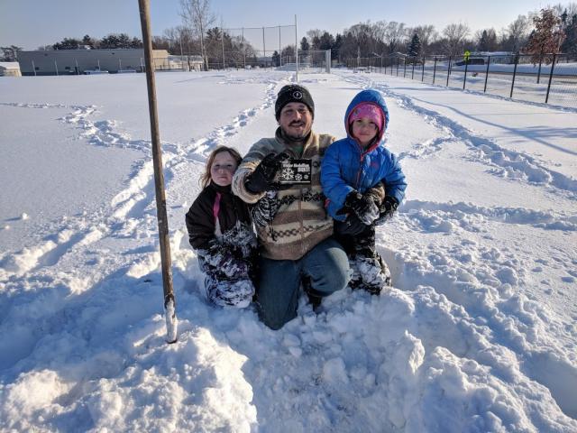 David Briese poses with the 2020 Winterfest Medallion and daughters Rainn and Helen in Ramsey after finding the idol at 3:30 p.m.