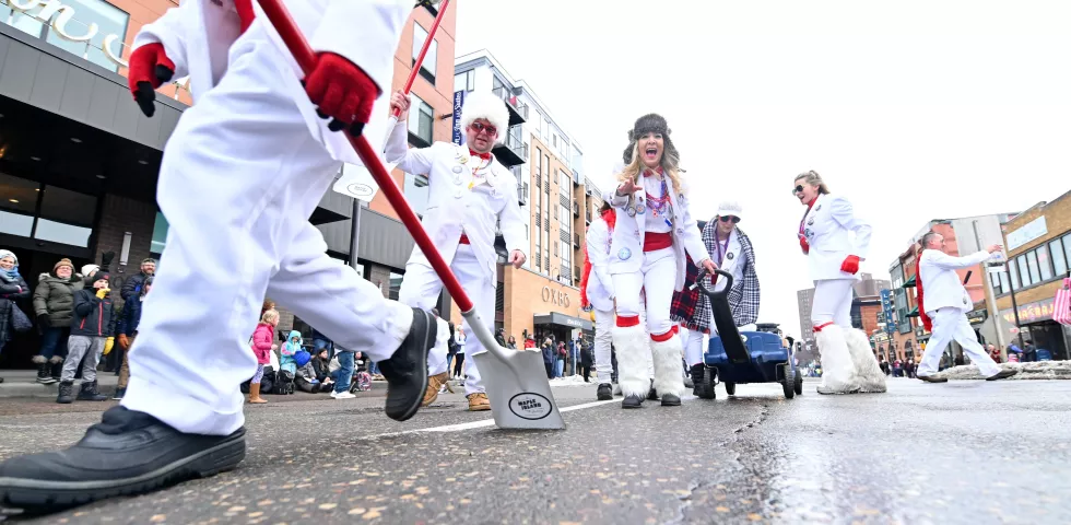 Members of the Tux Team Pooper Scoopers ply their trade during the 2020 St. Paul Winter Carnival King Boreas Grand Day Parade in downtown St. Paul on Saturday, Jan. 25, 2020. (John Autey / Pioneer Press)