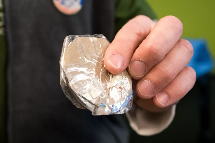 Two pieces of cardboard surround the 2019 Pioneer Press Treasure Hunt medallion found late Wednesday, Jan. 30 at Long Lake Regional Park in New Brighton. John Collins of Fridley holds the packaging, made from a cereal box, Thursday just before receiving his $10,000 prize for finding the medallion. He said the cardboard made it look like a dead leaf. (Andy Rathbun / Pioneer Press)