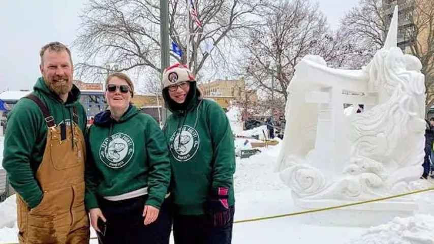 Adam Turner, Jaymie Stocks and Heather Friedli stand in front of their winning sculpture Saturday, Feb. 2, 2019. (Courtesy of Team Dino Fight)