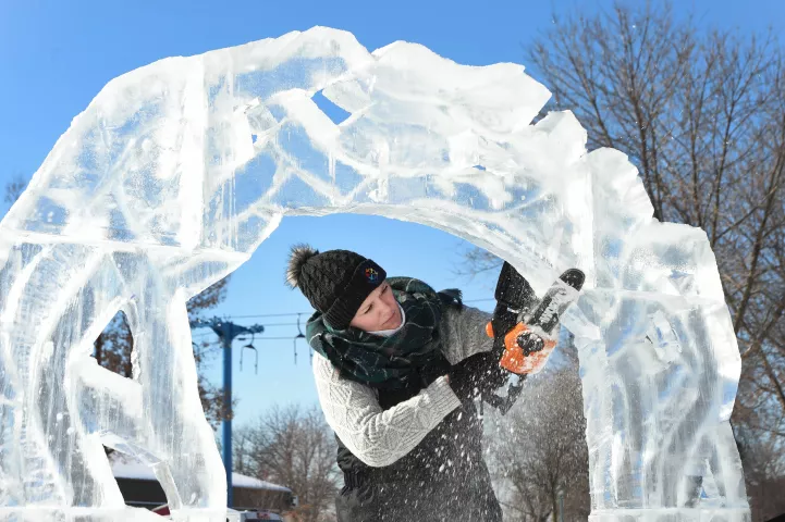 Taylor Richmond of Des Moines Iowa uses a chain saw to carve a vine-covered arch for her "Fairy Among the Flowers" ice sculpture at the Minnesota State Fairgrounds in Falcon Heights, Sunday, Jan. 24, 2021. This year's St. Paul Winter Carnival event is not a competition as in other years, due to it being a paid drive-through event open to paying vehicles only, each day from January 28th February 7th. (Scott Takushi / Pioneer Press)