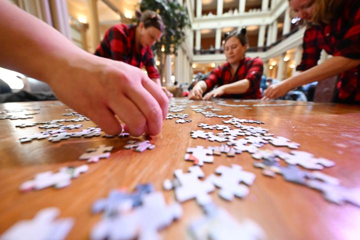 The family and friend team of (from left) Jill Derouin, reaching for puzzle piece, from Minneapolis, Laura Scott from St. Paul, Janae Derouin from Detroit Lakes and Emily Mehr-Kodada from Marine on St. Croix work to put their puzzle together at the 2023 Winter Carnival Jigsaw Puzzle Contest at Landmark Center in St. Paul on Saturday, Jan. 28, 2023. (John Autey / Pioneer Press)