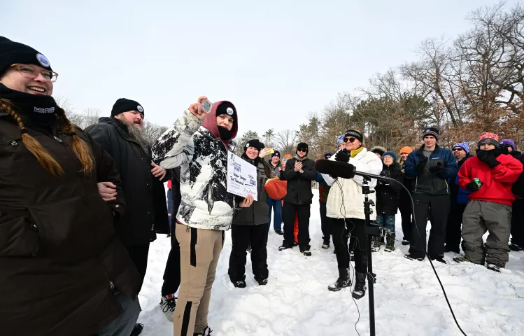 Surrounded by friends, family and fellow treasure hunters, Skyler Sawyer, of St. Paul, shows off the Pioneer Press Treasure Hunt medallion he found at Silverwood Park in St. Anthony on Monday, Jan. 31, 2022. (John Autey / Pioneer Press)