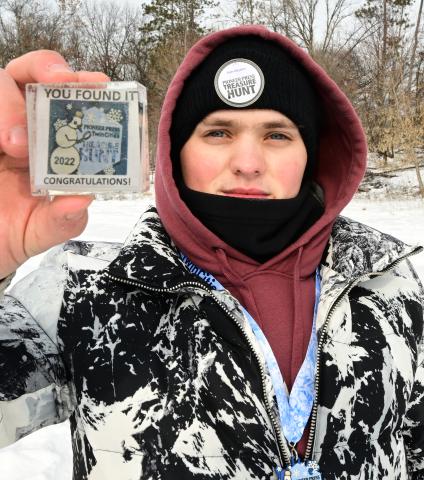 kyler Sawyer, of St. Paul, holds up the Pioneer Press Treasure Hunt medallion he found at Silverwood Park in St. Anthony on Monday, Jan. 31, 2022. (John Autey / Pioneer Press)