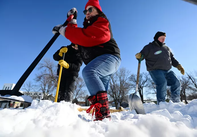 Tina Bruner, center, from Lino Lakes joins Tony Barrett, left, from Fridley and Jim Libke from St. Anthony at the Vulcan Snow Park in “Snow Stomping” at the Minnesota State Fairgrounds on Saturday, Jan. 22, 2022. Volunteers helped stomp the snow into 21 8-foot cubes for use in Winter Carnival snow sculptures. (John Autey / Pioneer Press)